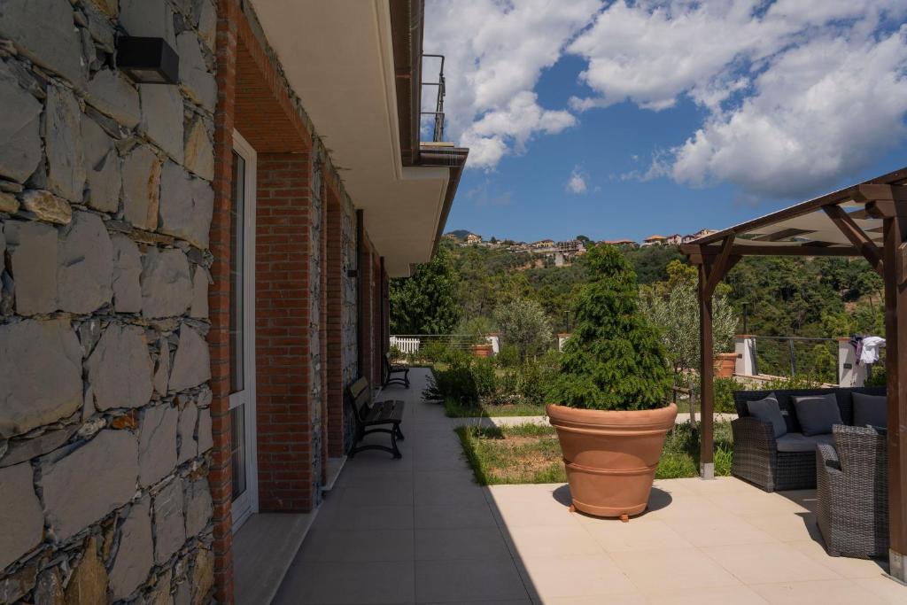 patio z rośliną w garnku obok budynku w obiekcie 065 - VILLA LETIZIA, Elegante 2 PISCINA e Natura, 10 minuti da MARE e SPIAGGIE w mieście Casarza Ligure