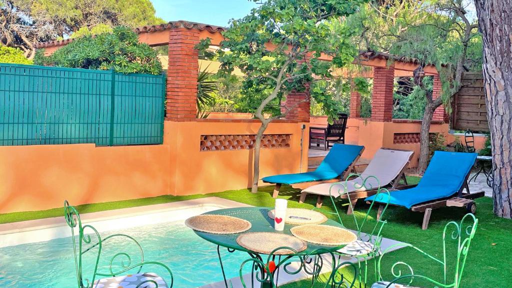 un patio avec tables et chaises à côté d'une piscine dans l'établissement Semaphore 24, à Sainte-Maxime