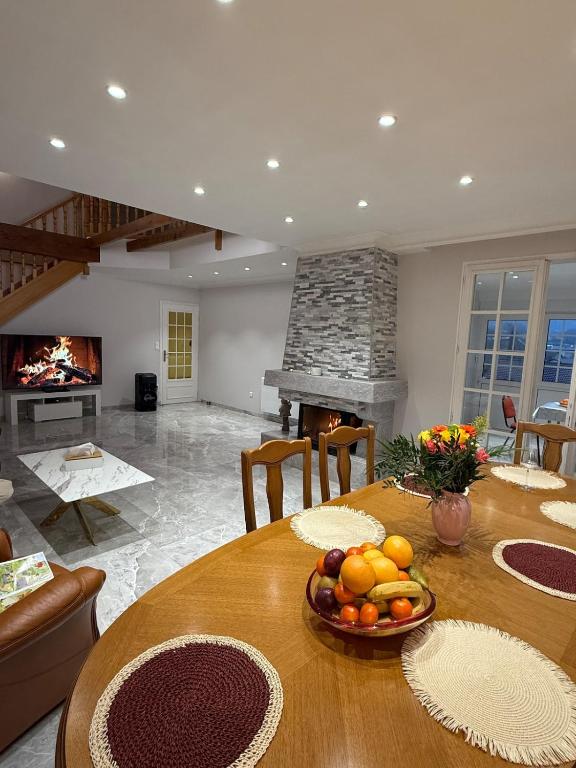 sala de estar con mesa de madera y chimenea en Villa Le domaine des Reves, en Hauteville-Lompnes