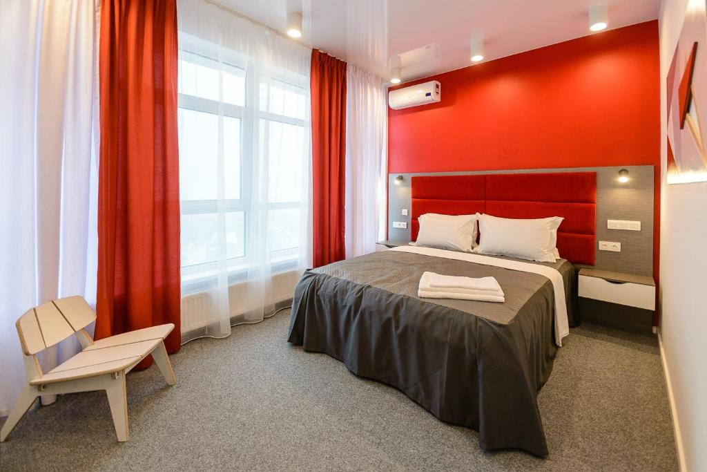 a bedroom with a bed and a red wall at Partner Guest House Klovs'kyi in Kyiv