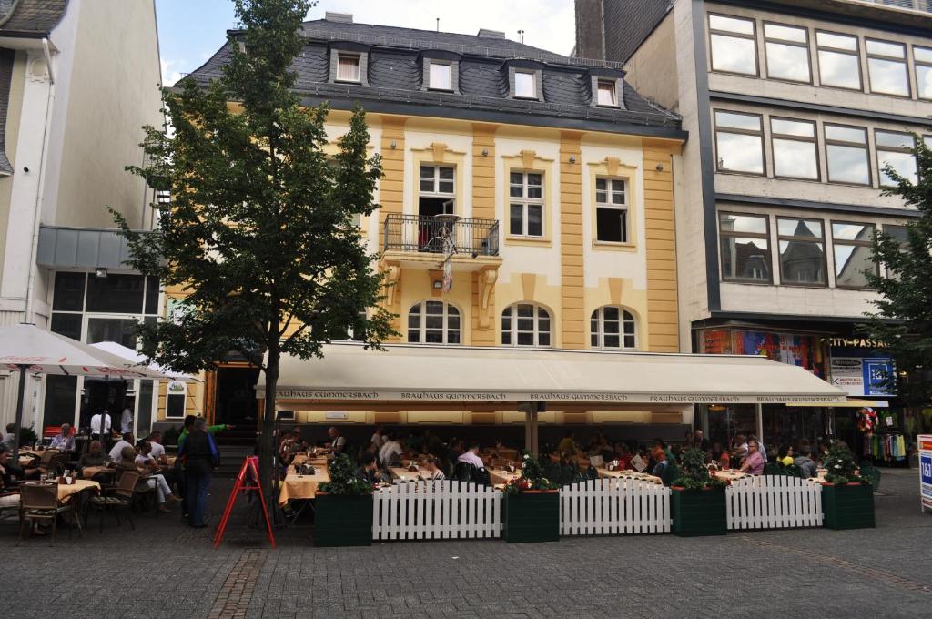 a group of people sitting at tables in front of a building at Brauhaus Gummersbach GmbH in Gummersbach