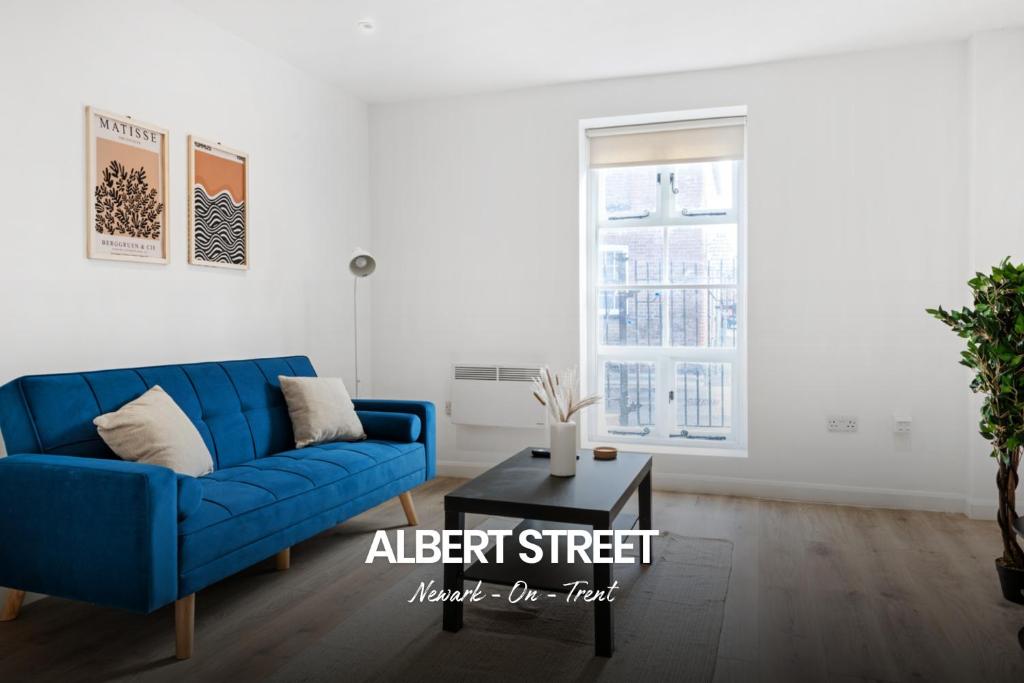 a living room with a blue couch and a table at Spacious 1-bed Apartment in Newark on-Trent by Renzo, Central Location, Free Parking! in Newark upon Trent