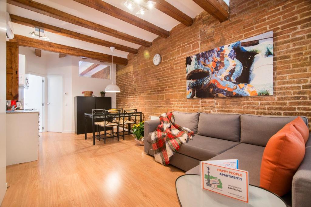 a living room with a couch and a brick wall at Happy People Ramblas Harbour Apartments in Barcelona