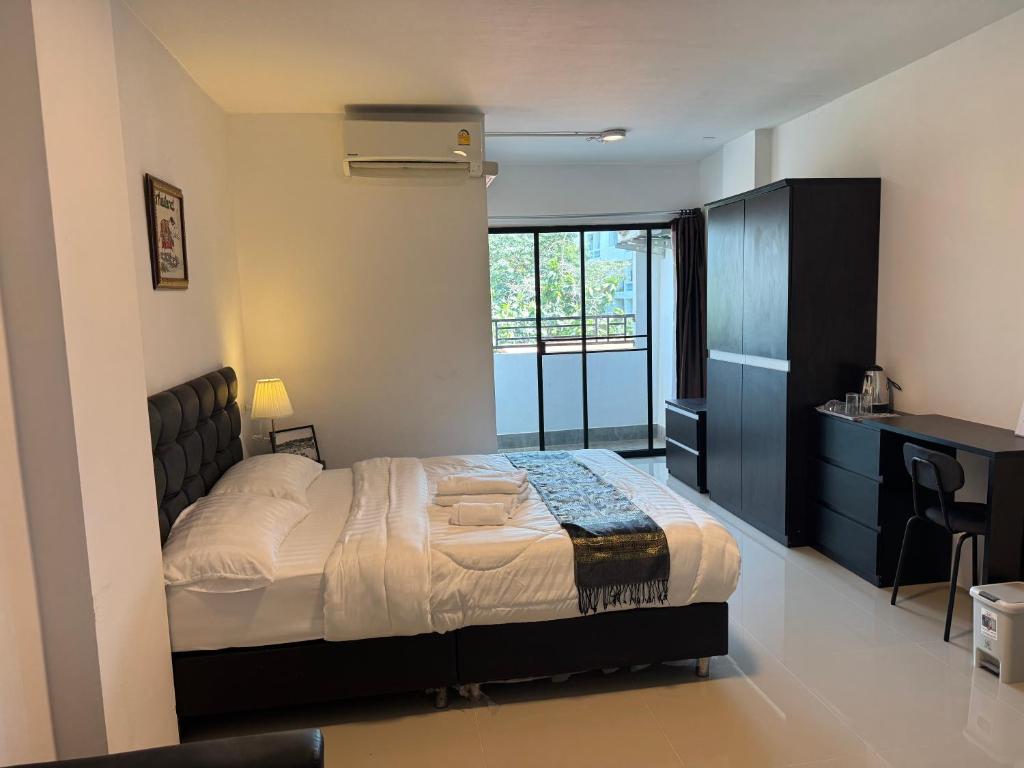 a bedroom with a bed and a desk in it at ณัฐพิมลเพลส์ 3 in Bangkok Yai