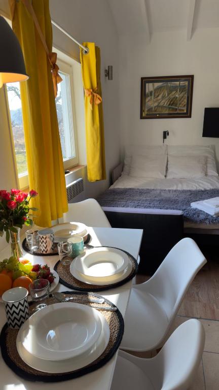 a room with a table and chairs and a bed at Domki Przy Pracowni in Wytowno