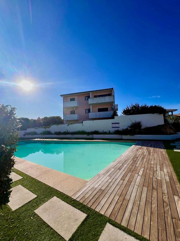 a swimming pool with a building in the background at Appartamento Sardinia Escape in residence - Palau in Palau