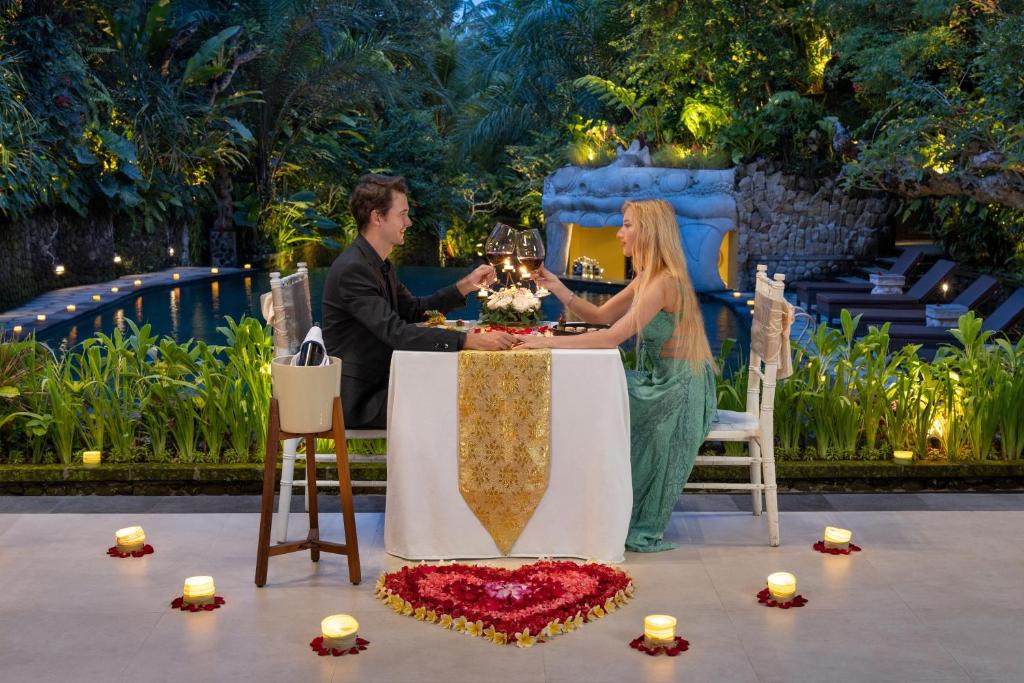 ウブドにあるSakti Garden Resort & Spaのワインを飲みながら座る男女
