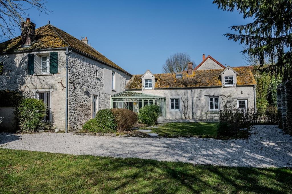 une vieille maison en pierre avec une grande cour dans l'établissement Grande Maison de Charme- 14 pers- 1h Paris, à Gressey