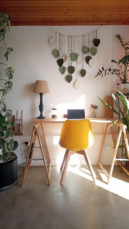 a yellow chair in a room with plants at Kanela Guest House B-side in Machico