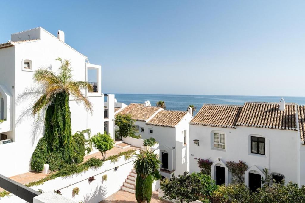 a row of white houses with the ocean in the background at Casa Lola in Sitio de Calahonda