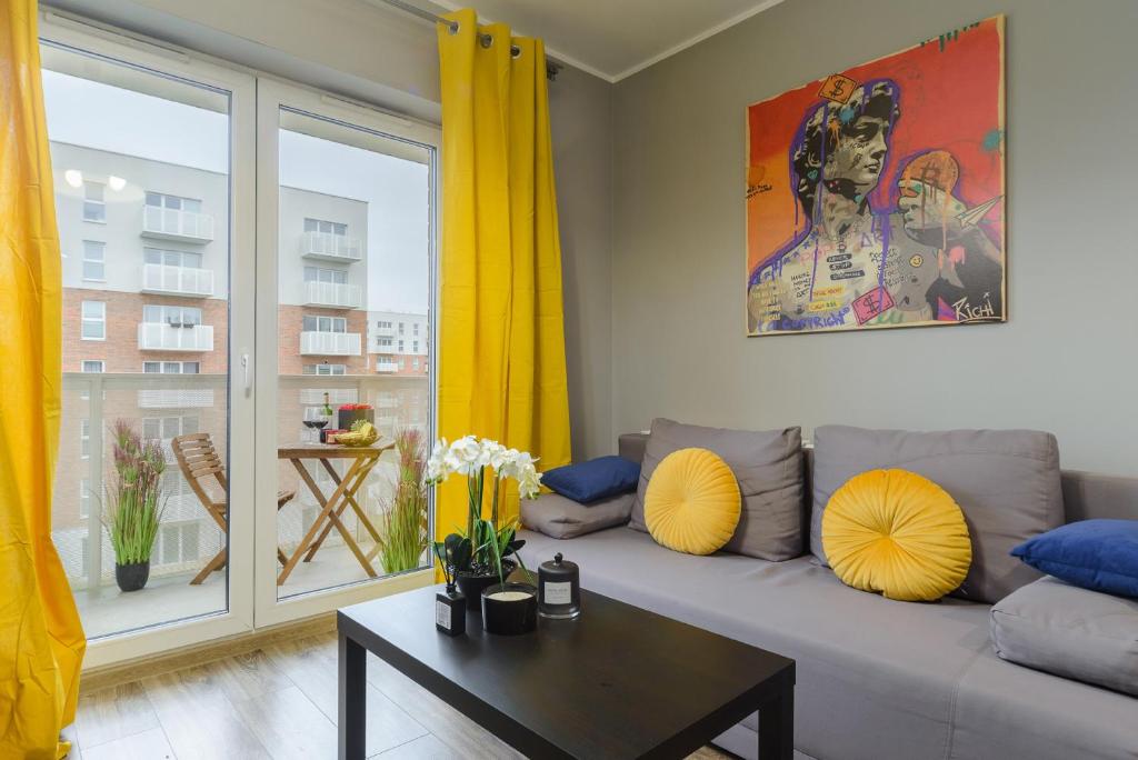a living room with a gray couch and yellow curtains at Lumina I Comfy Apartments with Balcony I Parking I Pasaż Łódzki in Łódź