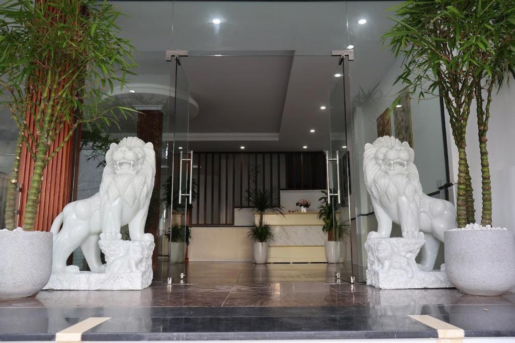 zwei weiße Löwenstatuen in einer Lobby in der Unterkunft The Grand Diamond C Hotel in Trung Ðồng