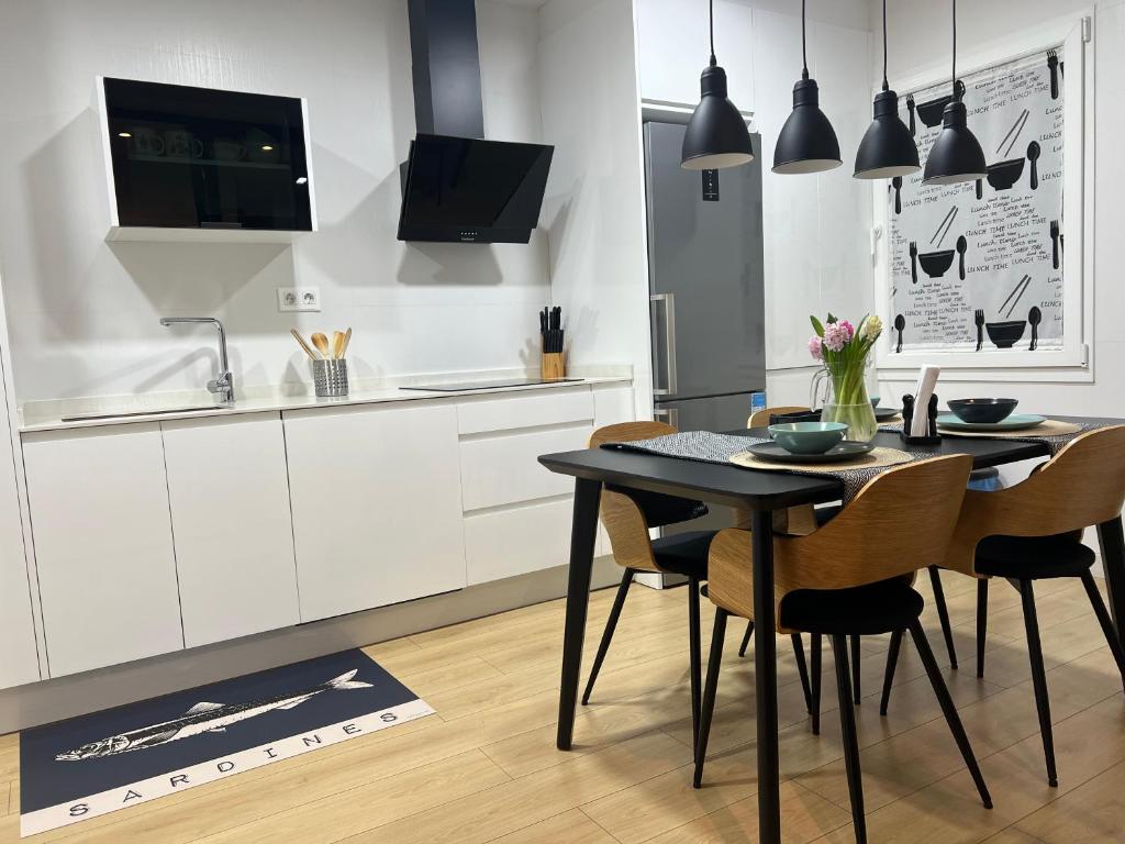 Una cocina con mesa de comedor y sillas. en TU CASA - Parking y terraza VUT 177-AS, en Gijón