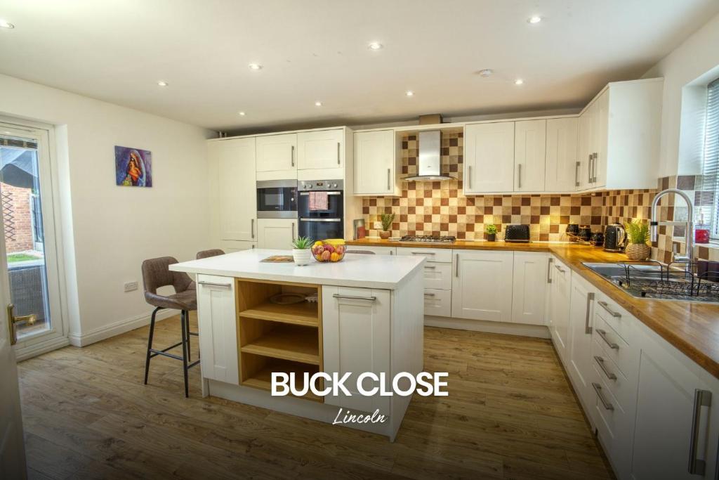 a large kitchen with white cabinets and a counter at Incredible and Charming 4-bed Home in Lincoln by Renzo, Free Parking, Close to Lincoln Hospital! in Lincoln