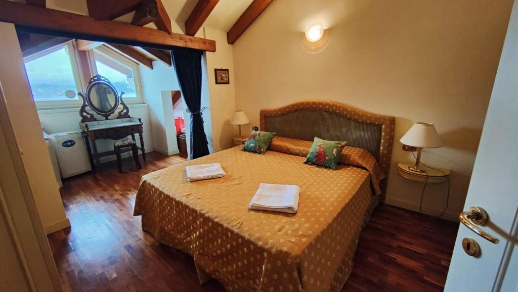 una camera da letto con un letto con due asciugamani sopra di Scarlet Flower - Lago Maggiore a Meina
