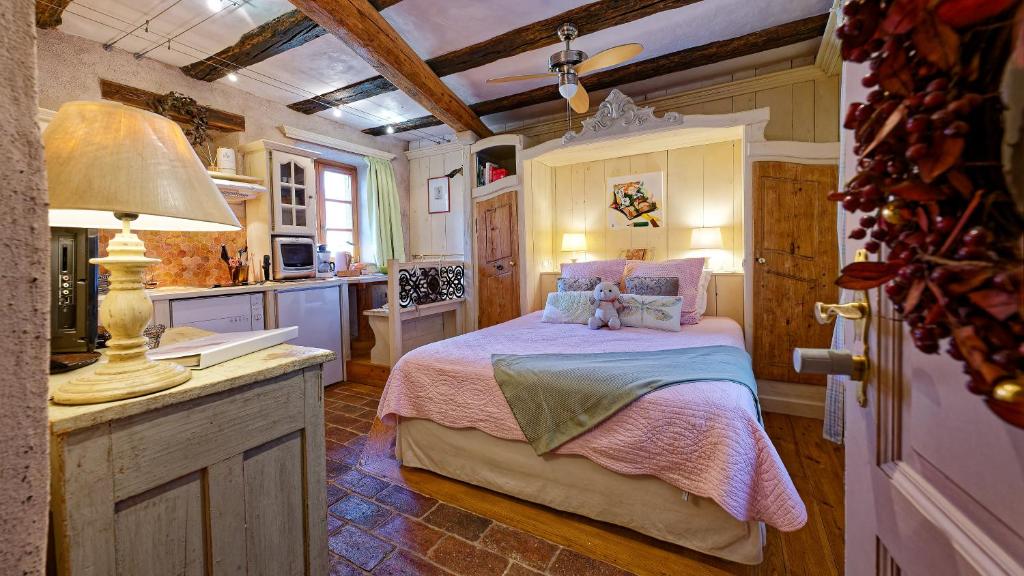 sypialnia z łóżkiem i kuchnią w obiekcie Remparts de Riquewihr - Refuge du Lutin - Studio w mieście Riquewihr