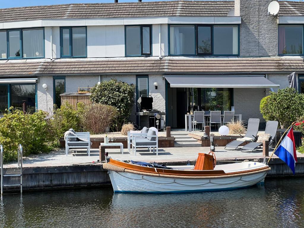 a boat sitting in the water in front of a house at HBW4 - Lemmer in Lemmer