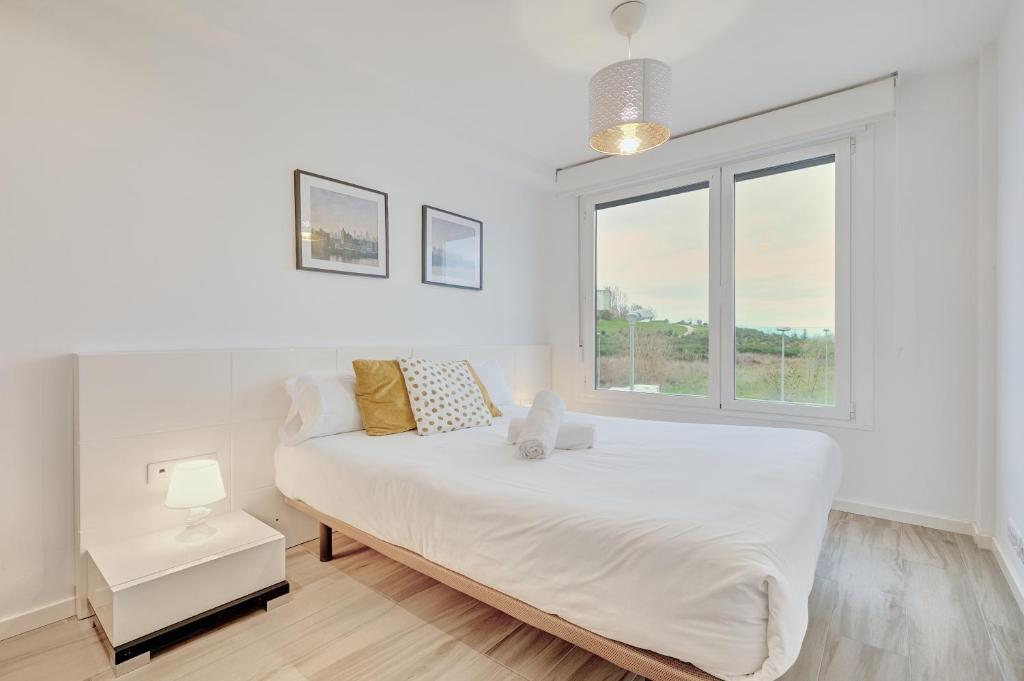 a white bedroom with a bed and a window at Ripa by Clabao in Burlada