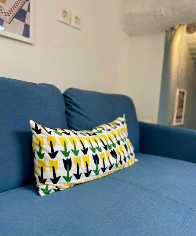 - un canapé bleu avec un oreiller coloré dans l'établissement Le Petit Rome Proche gare, à Lyon