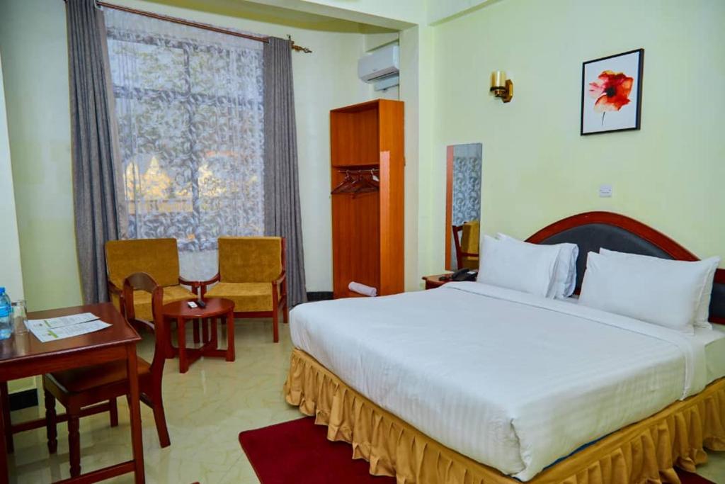 a hotel room with a bed and a desk and a bed at KiliCrane Lodge Arusha in Arusha