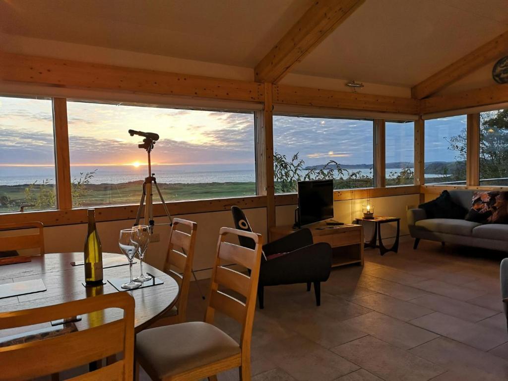 a living room with a table and a view of the ocean at Nautilus Tenby in Tenby