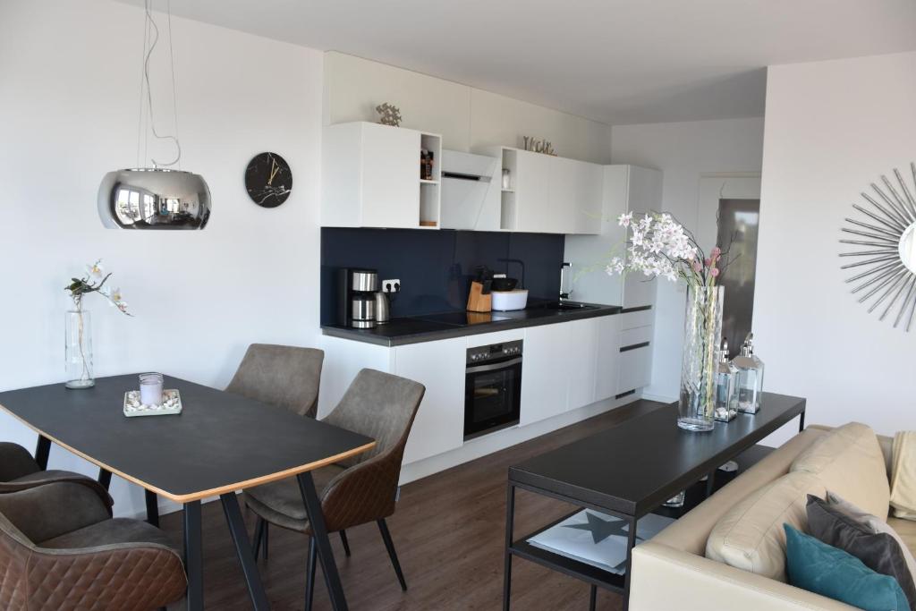 a living room with a table and a kitchen at Ferienappartement "Liegeplatz" in Sassnitz