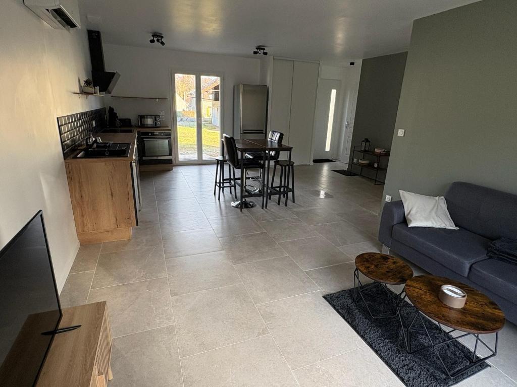 un salon avec un canapé bleu et une cuisine dans l'établissement Gîte 3 Ptits Chats, à Saint-Aubin