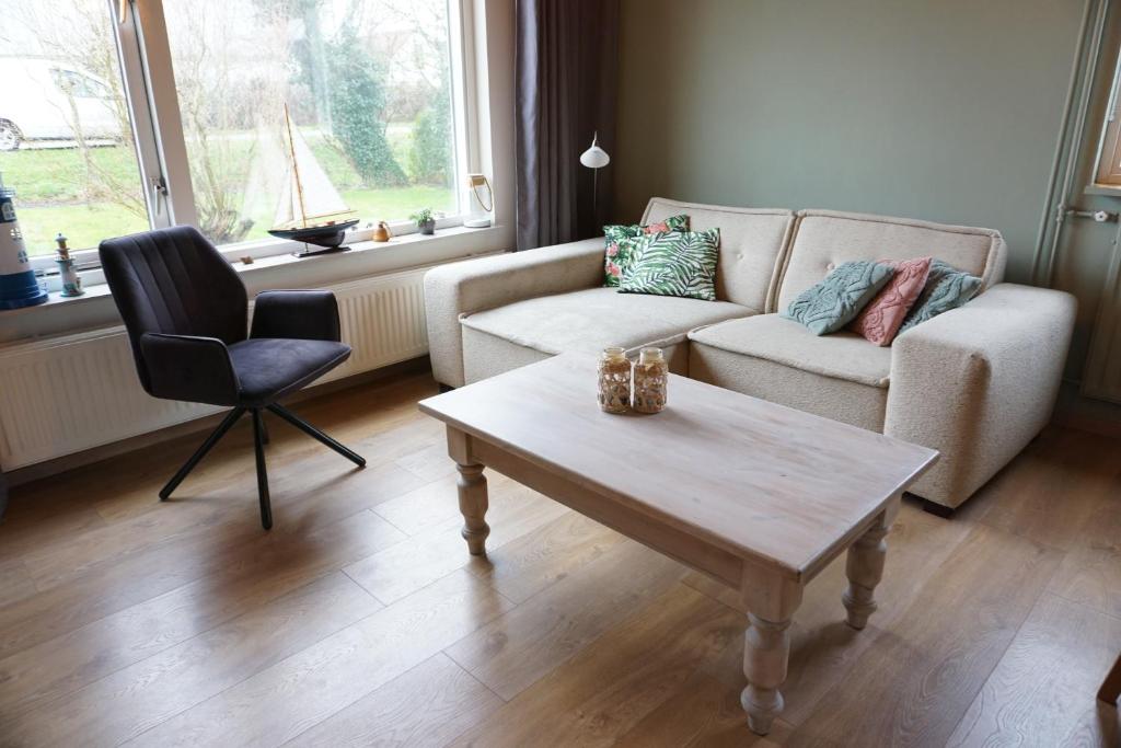 a living room with a couch and a table and a chair at Kustverhuur, Breskens, 't Zandertje in Breskens