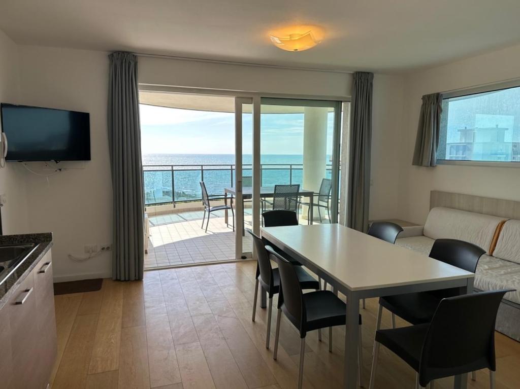 a living room with a table and a view of the ocean at Sky Residence in Lignano Sabbiadoro