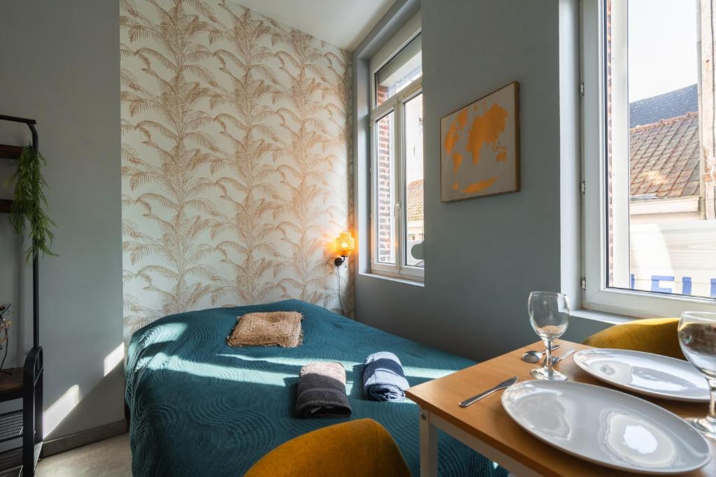 Cette chambre comprend un lavabo, un lit et une table. dans l'établissement Le nid douillet - Rez-de-chaussée - Calme & confortable, à Valenciennes