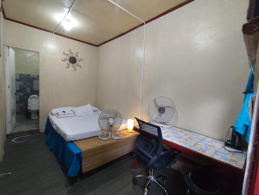 a small room with a bed and a desk with a desk at TerisitaPlace - BamboRoom in Taytay