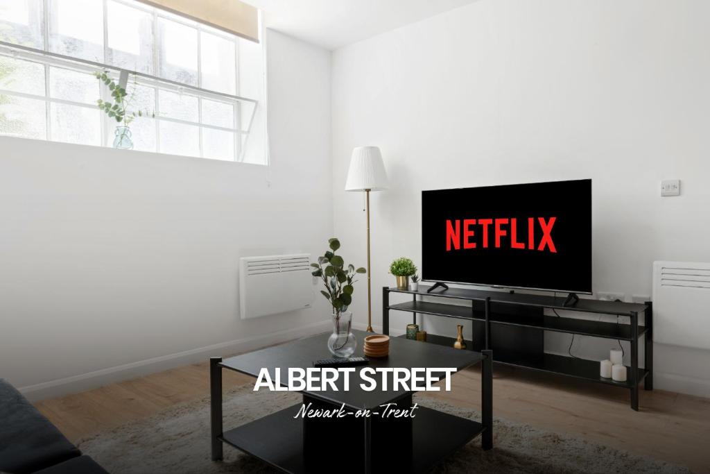 een woonkamer met een flatscreen-tv op een entertainmentcentrum bij Gorgeous 1-bed Apartment in Newark on-Trent by Renzo, Free Parking, Sleeps 4! in Newark upon Trent