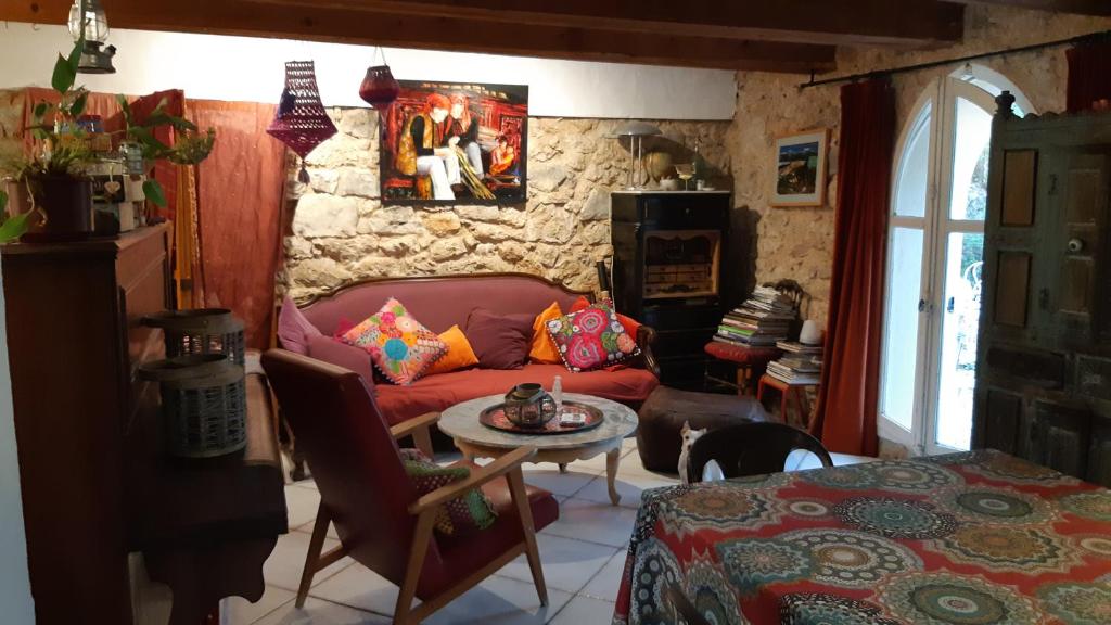 a living room with a red couch and a table at Le Mas Nomade in Callian