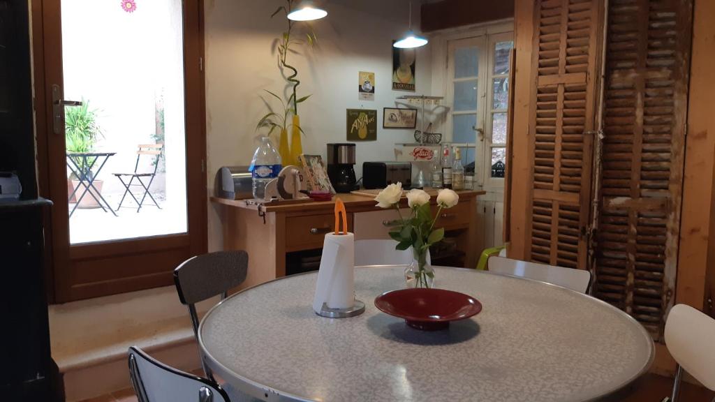 a dining room table with a vase of flowers on it at Le Mas Nomade in Callian