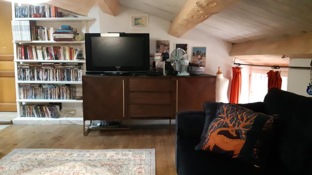 a living room with a couch and a tv on a dresser at Le Mas Nomade in Callian