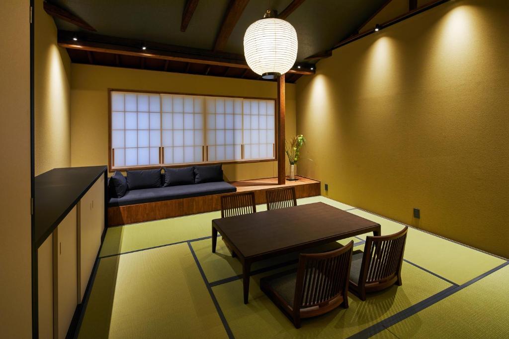 a dining room with a table and chairs and a window at UNO RETREAT Kyoto Gluten Free & Vegan Hotel in Kyoto