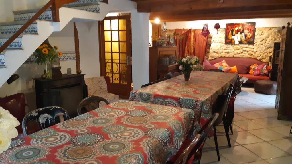 a dining room with two tables and a couch at Le Mas Nomade in Callian
