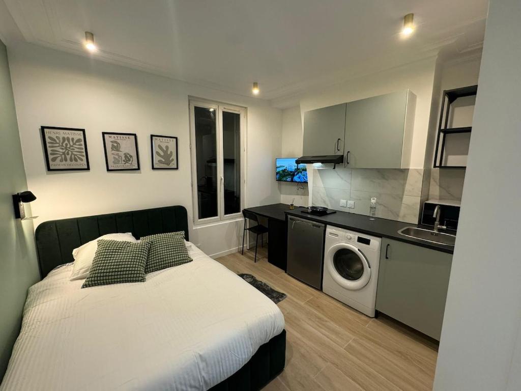 Il comprend une chambre avec un lit et une cuisine équipée d'un lave-linge. dans l'établissement Studio Luxe Paris, à Clichy