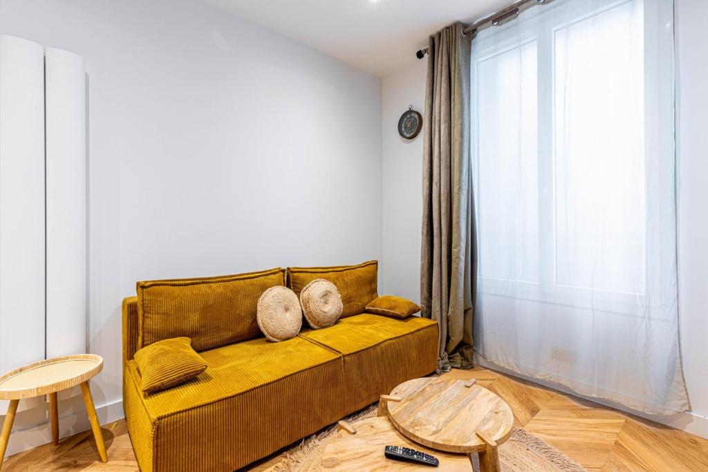- un salon avec un canapé jaune et une fenêtre dans l'établissement GuestReady - Tranquil Gem, Steps from the Metro, à Paris