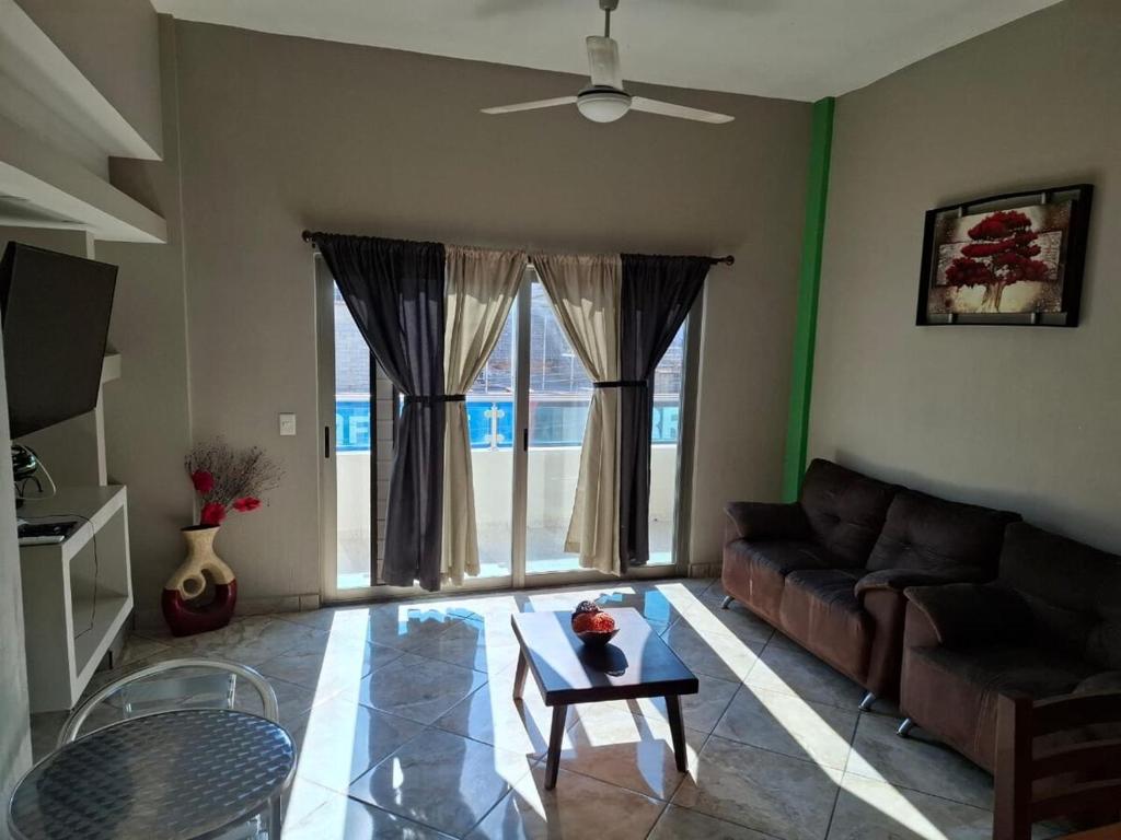 ein Wohnzimmer mit Sofa und Tisch in der Unterkunft Departamentos La roca D2 in La Peñita de Jaltemba