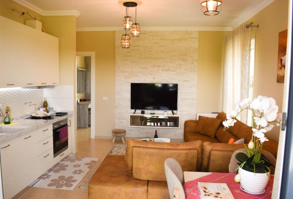 a living room with a couch and a tv at J & J Holiday Home Vala Mar in Hamallë
