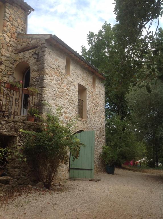a stone building with a green door on it at Le Mas Nomade in Callian