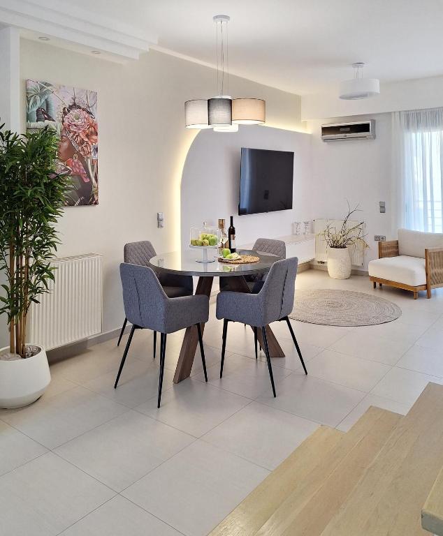a dining room and living room with a table and chairs at Lux home in central location in Ierapetra
