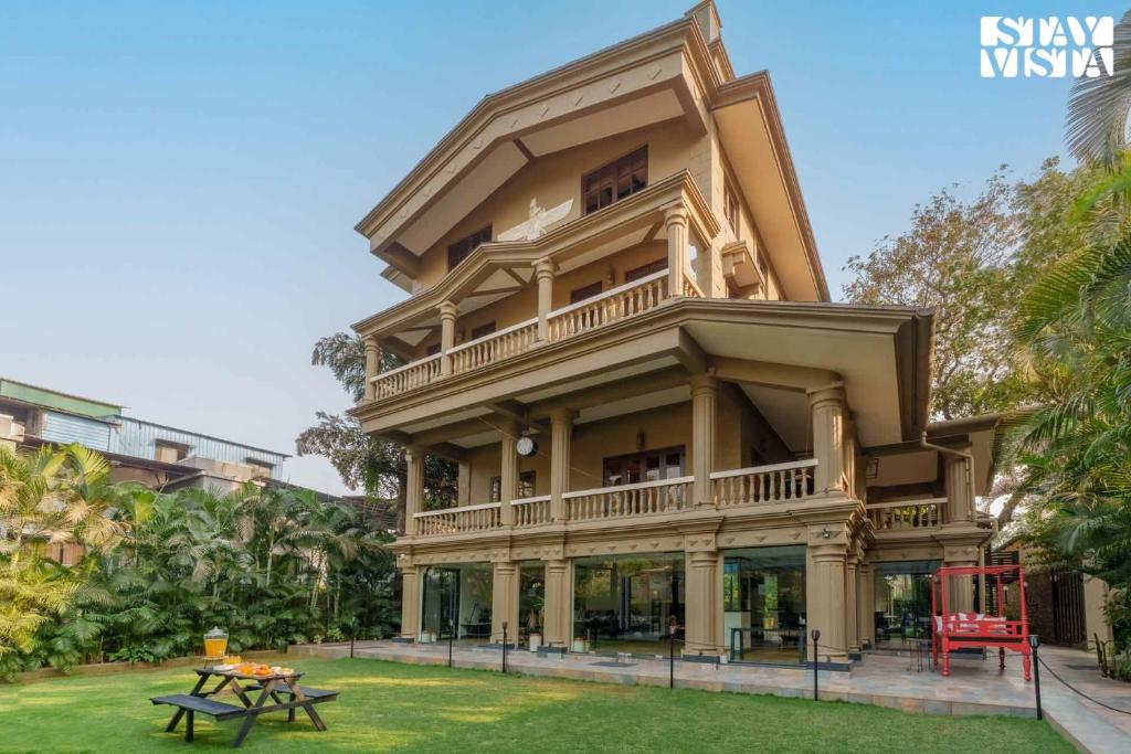 a large building with a table in front of it at Mehta Mansion by StayVista - A Villa with a Swimming Pool and Pool Table in Lonavala