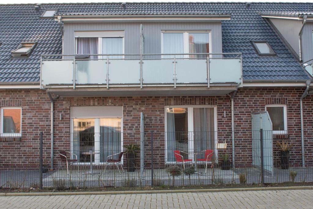 ein Backsteingebäude mit Stühlen auf einem Balkon in der Unterkunft Hotel Sonne am Meer in Norddeich