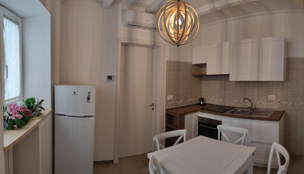 uma cozinha com armários brancos e uma geladeira branca em Antica Dimora Vada' em Alberobello