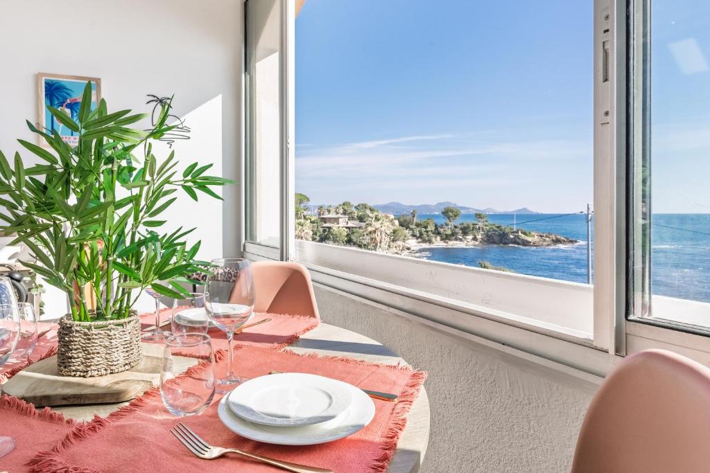 Un comedor con mesa y vista al mar. en Appart le Grand Bleu Saint Aygulf, en Fréjus