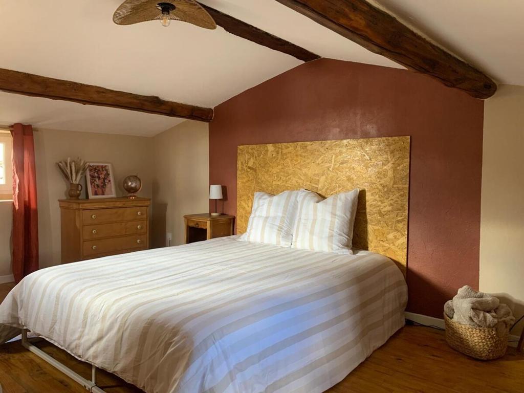 a bedroom with a large bed and a brown wall at Maison calme - Rue piétonne - Ardeche - ViaRhona - Dolce Via in La Voulte-sur-Rhône