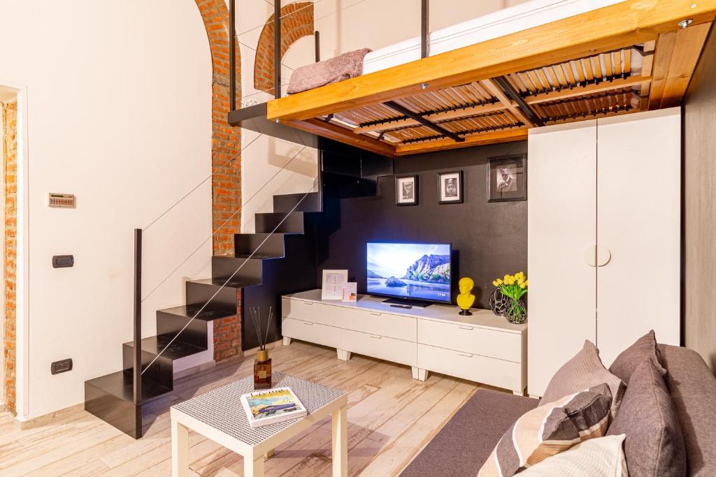 a living room with a staircase and a tv at Casa Volturno - 5 min dalla stazione in Monza