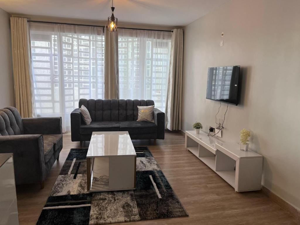 a living room with a couch and a table at Treands Apartments in Nakuru